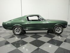 a green mustang sitting on top of a checkered floor