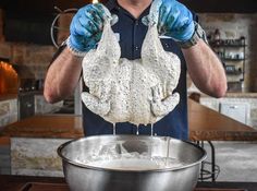 a man in blue gloves is mixing something in a bowl