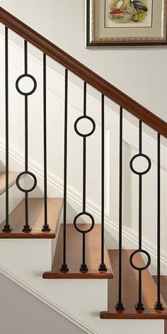 a set of stairs with metal railings and wood handrails in a home