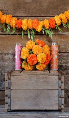 an arrangement of flowers and candles on a wooden crate