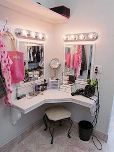 there is a vanity with lights on it and a stool in front of the mirror