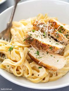 a white bowl filled with chicken and pasta