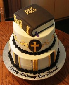 a cake with a book on top and a cross on the bottom is sitting on a table