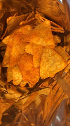 some chips are in a plastic bag on the table and it looks like they have been cooked