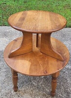 an old wooden table with two tiered shelves on the bottom and one shelf in the middle