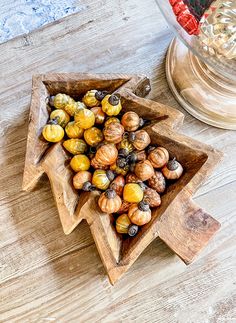 two wooden trays filled with different types of nuts on top of a table next to a glass vase