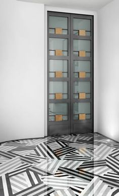 an empty room with a glass door and black and white floor tiles on the floor