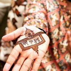 a woman holding out her hand with hendi designs on it and writing in the middle