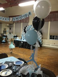 a baby shower is set up with balloons and plates on the table in front of it