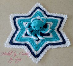 a crocheted blue and white star with an elephant on it