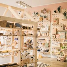 a room filled with lots of wooden shelves covered in pictures and plants on the wall