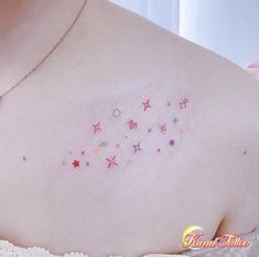 the back of a woman's shoulder with small stars and hearts on her chest