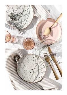 plates and utensils laid out on a striped table cloth with flowers in them