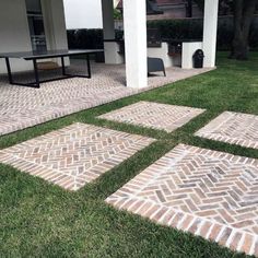 an outdoor patio with brick pavers on the grass