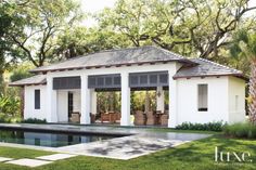 the pool house is surrounded by trees and grass