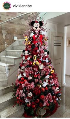 a christmas tree decorated with minnie mouses and other holiday decorations on top of it