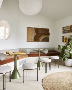 a living room filled with white furniture and lots of plants on top of it's tables