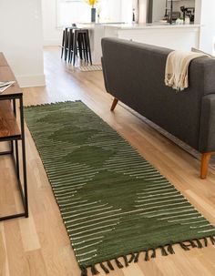 a living room with a couch and rug on the floor