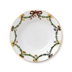 a white plate with gold trim and holly decorations on the rim, decorated with red bows