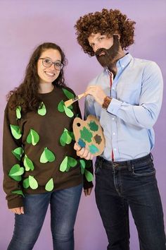 a man and woman are dressed up as the same person with paintbrushes in their hands