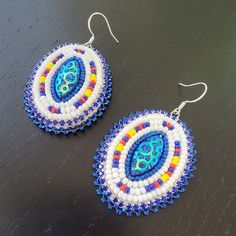 two pairs of beaded earrings sitting on top of a table