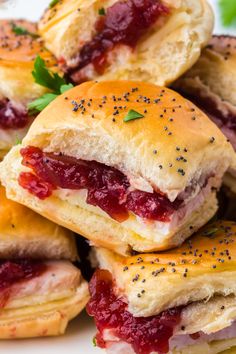 a pile of ham and cheese sliders sitting on top of a white platter