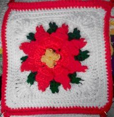 a red and white crocheted bag with flowers on it