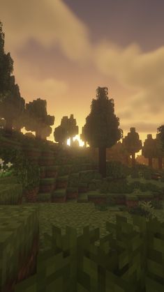 the sun is setting over an area with trees, bushes and grass on it's sides