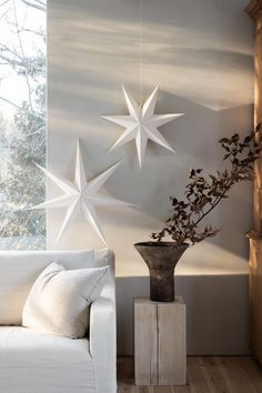 a living room with a white couch and star decorations on the wall next to a window