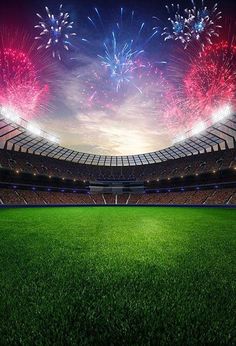 an empty soccer stadium with fireworks in the sky