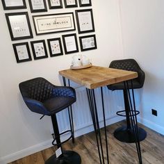 two chairs and a table with pictures on the wall