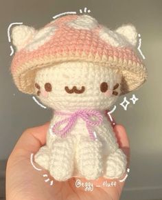 a small crocheted white teddy bear wearing a pink hat