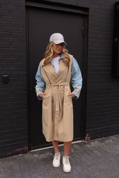 DETAILS: Introducing our stylish Paige Khaki Combo Trench Coat, a unique statement piece for the colder days ahead! This maxi-length coat features an innovative design with a denim jacket base layered underneath a sleeveless khaki trench coat, creating a distinctive and eye-catching look. The khaki details on the denim long sleeve cuffs add an extra touch of flair. With two rows of buttons and a wrap-around tie closure, this coat offers versatility in styling and fit. Crafted from a lightweight, Oversized Denim Outerwear For Work, Trendy Belted Long Coat, Chic Oversized Cotton Outerwear, Denim Outerwear For Fall Layering, Oversized Gabardine Outerwear For Fall, Utility Long Coat For Work, Fall Denim Belted Outerwear, Chic Oversized Gabardine Outerwear, Chic Cotton Outerwear For Spring