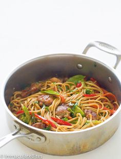 a pan filled with noodles and vegetables on top of a table