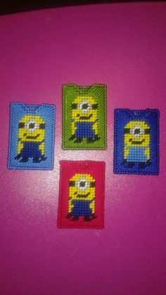 four minion coasters sitting on top of a pink table