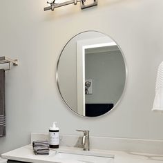 a bathroom with a sink, mirror and towel rack