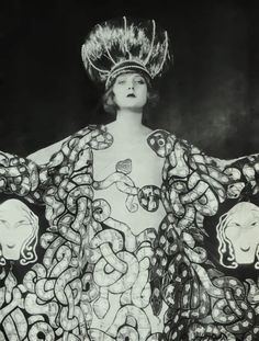 a black and white photo of a woman in an elaborate dress