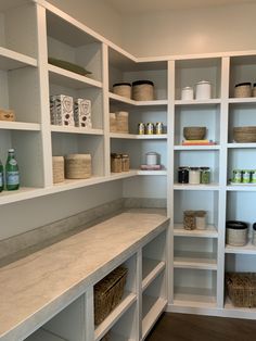 an organized pantry with white shelving and baskets