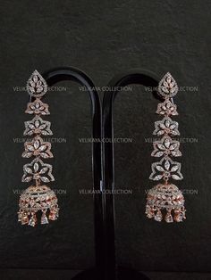 Long statement earrings with brilliant American Dimond CZ stones. Adorned with flower motif and jhumkis at the bottom. Length - 3 inch Width - 1 inch Weight - 14 grams ----------- CARE ----------- - Store in air tight zip lock bags - Do not expose to moisture/water - Do not spray chemicals or perfumes on the jewelry - Do not drop on hard surfaces Please feel free to contact us if you have any questions. * We sell high quality imitation jewelry only. All measurements are approximate. Please note that all sales are final. Thank you Rose Gold Earrings For Wedding And Festive Occasions, Festive Rose Gold Wedding Earrings, Fusion Style Party Chandelier Earrings With Latkans, Hand Set Danglers For Party And Festive Occasions, Hand Set Danglers For Party And Festive Season, Festive Rose Gold Earrings For Gift, Fusion Style Drop Earrings Danglers For Party, Heavy Fusion Bridal Earrings For Party, Heavy Fusion Style Bridal Earrings For Party