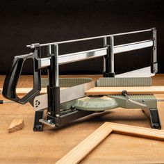 a machine that is sitting on top of a wooden table next to some pieces of wood