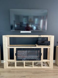 a flat screen tv mounted to the side of a wooden entertainment center in a living room