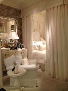 a bedroom with white furniture and curtains