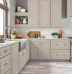 a kitchen with gray cabinets and tile flooring