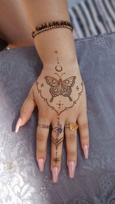 a woman's hand with henna tattoos on it