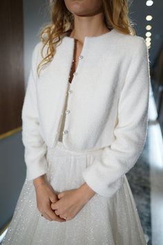 a woman wearing a white dress and jacket