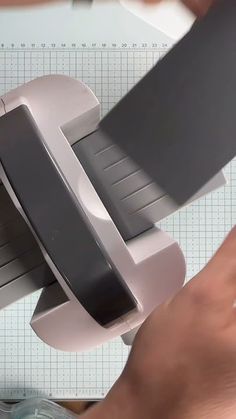 a person using a device to cut paper