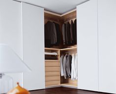 an open closet with clothes hanging in it