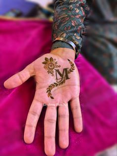 a woman's hand with henna tattoos on her left arm and palm in the middle