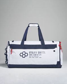 a duffel bag with the words utility duffel printed on it, sitting against a grey background