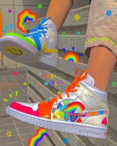 a person wearing white sneakers with rainbow painted on them